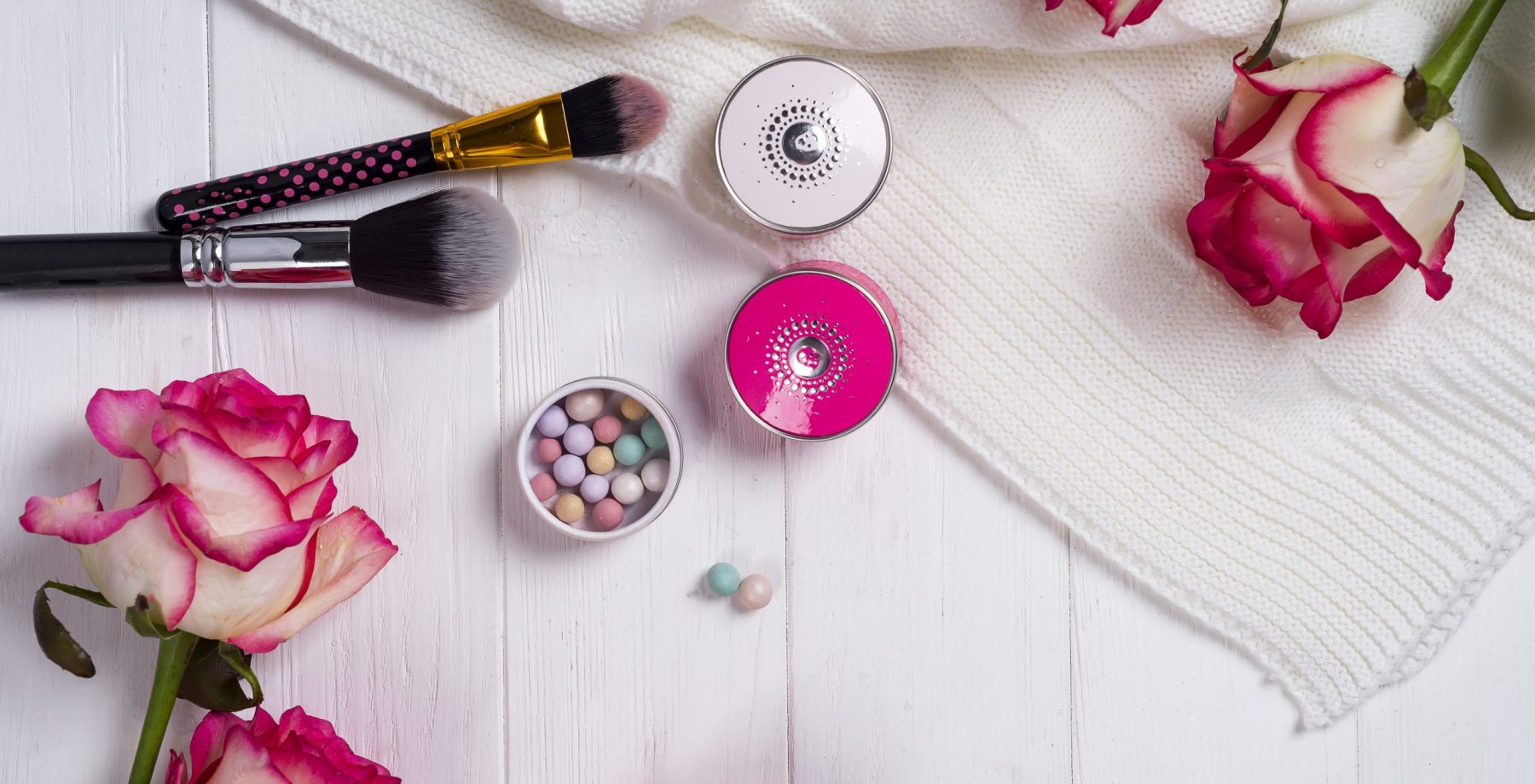 Beautiful flat lay with flowers, cosmetics and other accessories, concept of a woman's workplace, white background, copy space